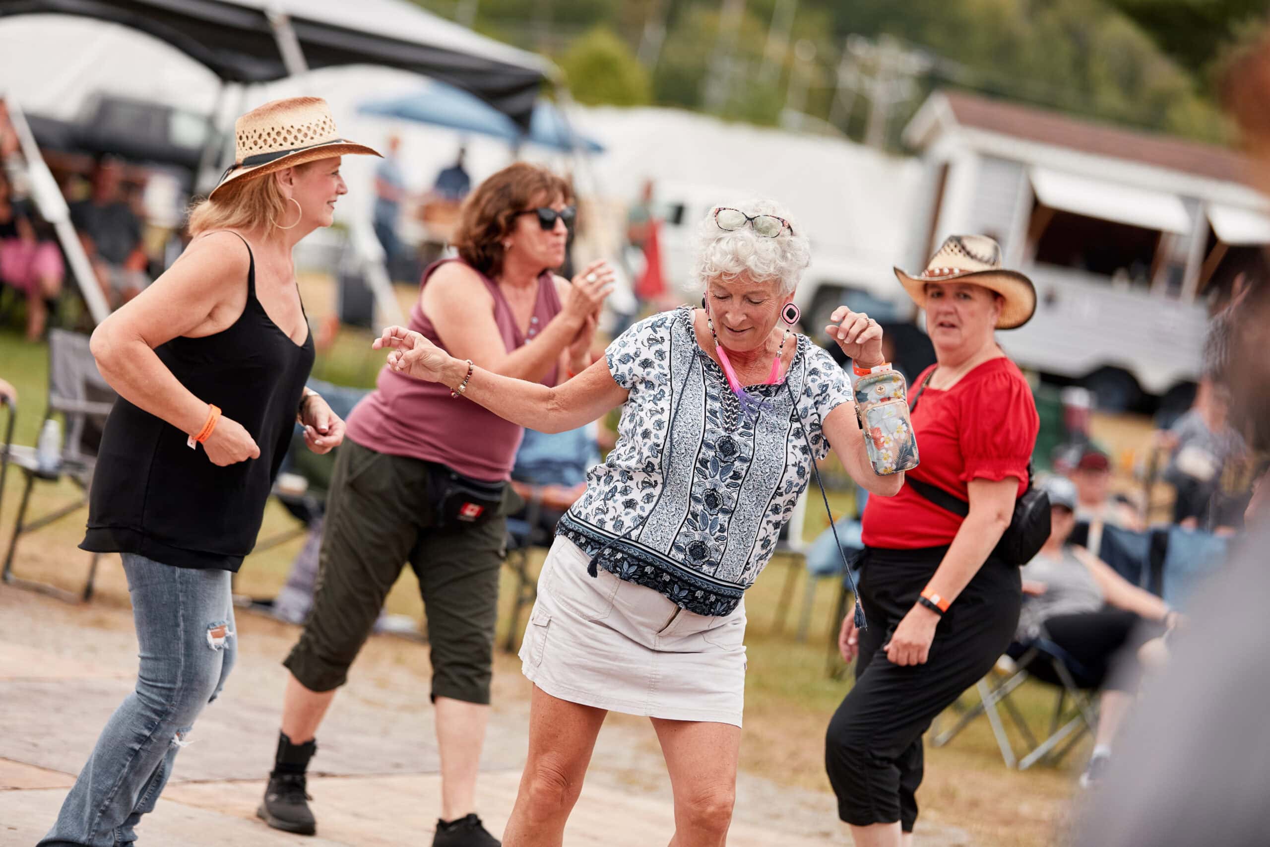 Four women dance at the Countryfest Music Festival in Kebaowek.